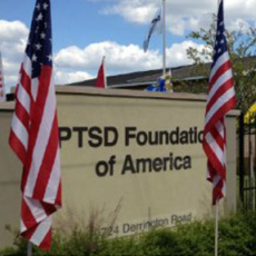 PTSD Foundation of America sign surrounded by multiple American flags